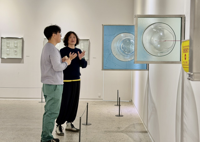 샘표 이천공장 직원이 샘표 스페이스 전시 작가로부터 작품 설명을 듣고 있다