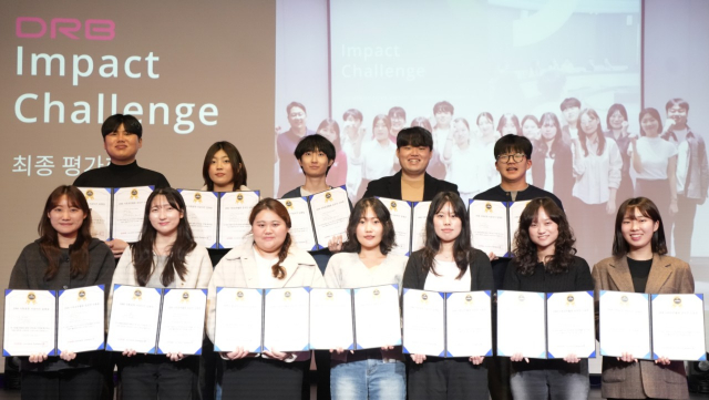 12월 20일 열린 ‘DRB Impact Challenge’ 최종평가회에서 12명의 대학생 참가자들이 3개월간의 사회공헌 프로젝트를 마치고 수료증을 들고 기념촬영을 하고 있다(사진=DRB)