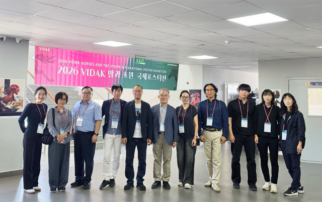 2026 VIDAK ‘말과 초원’ 국제포스터전이 열린 몽골 울란바토르 몽골과학기술대학교(MUST)​ 전시장에서 한국시각정보디자인협회(VIDAK) 노상용 회장과 회원 및 참가자들이 기념 촬영을 하고 있다