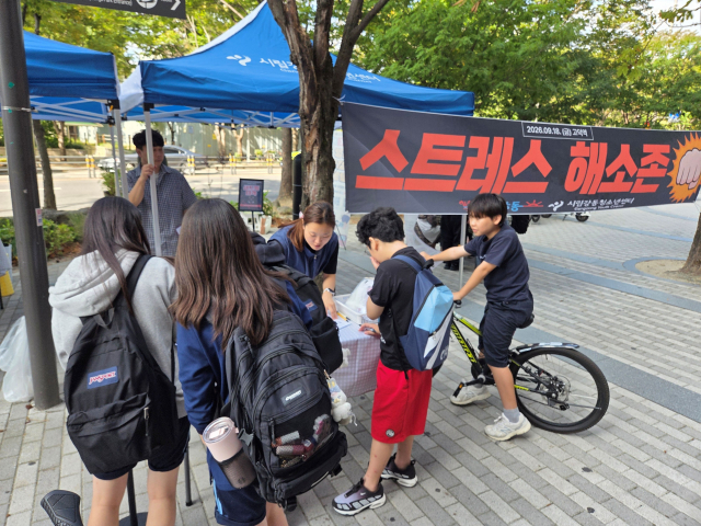 청소년들이 ‘스트레스 해소존’에서 마음진단지를 작성한 후 본인의 스트레스 유형에 대해 설명을 듣고 있다